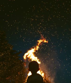 Small child silhouetted by fire